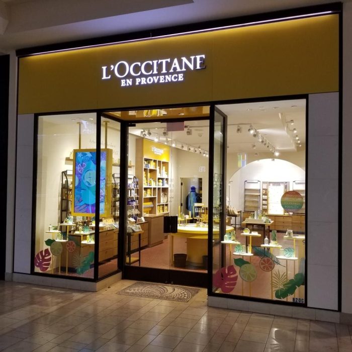Exterior view of a L'Occitane en Provence store in Mission Viejo mall, showcasing its brightly lit interior with enticing displays of products, adding to the vibrant shopping atmosphere.